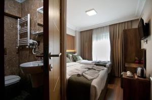 a hotel room with two beds and a sink at Aurora Eco Hotel in Istanbul