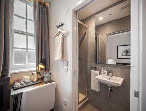y baño con lavabo y espejo. en King's Cross Express Inn en Londres