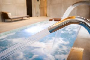 a faucet pouring water into a swimming pool at Hotel & Spa Convento San Francisco in Soria