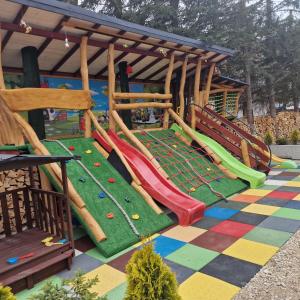 a playground with slides and play equipment on a colorful floor at Harenda in Zakopane