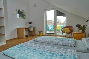 a bedroom with two beds and a balcony at EntdeckerFERIEN am Bodensee in Friedrichshafen