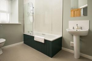 een badkamer met een wastafel, een bad en een toilet bij The Rushes in Bamburgh +25 foto's