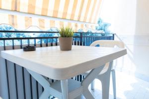 a white table with a potted plant on a balcony at Affittacamere Piazza Mazzini in Terracina