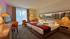 a hotel room with a large bed and a desk at Hotel & SPA Sommerfeld - Adults Only in Kremmen