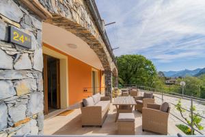a patio with chairs and tables and a stone wall at 267 - Casa Paradise B1, nel verde di Casarza a 15 minuti d'auto dal Mare - PARCHEGGIO PRIVATO INCLUSO in San Lazzaro +33 photos