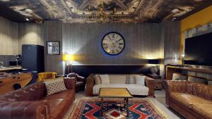 a living room with a couch and a clock on the wall at Villa Dei 15 pers jacuzzi, baby-foot, 30 min mer in Villedieu-les-Poëles