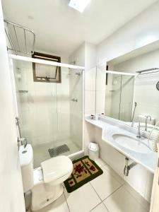 a bathroom with a toilet and a sink and a shower at Condomínio Aldeia dos Reis in Mangaratiba +25 photos