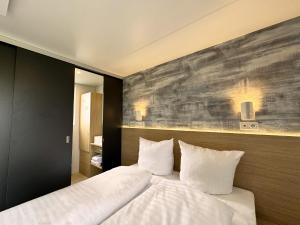 1 dormitorio con 1 cama grande con almohadas blancas en Golf Cubes Hohwacht en Hohwacht