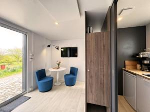 una cocina con 2 sillas azules y una mesa en Golf Cubes Hohwacht en Hohwacht