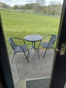 una mesa y dos sillas sentadas junto a una mesa en Ye Olde Bowling Green Inn en Bradwell