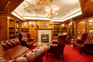 a living room with leather furniture and a fireplace at Hotel Solthus am See in Baabe