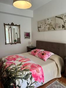 a bedroom with a bed with pink flowers on it at Casa Patrizia in Giardini Naxos