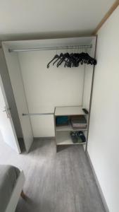 a room with a closet with a shelf with shoes at Mobil-home camping 4 étoiles N35 in Fourmies