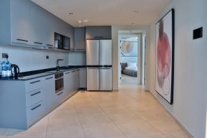 a kitchen with white cabinets and a stainless steel refrigerator at J 22 Residence in Lusail