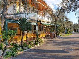 a building with a restaurant with plants in front of it at Camping Le Maior in Brenzone sul Garda