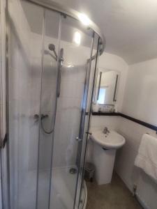 a bathroom with a shower and a toilet and a sink at Ye Olde Bowling Green Inn in Bradwell