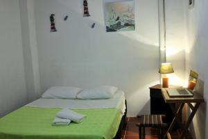 a bedroom with a bed and a desk with a laptop at Hospedaje Los Capuchinos in Socorro