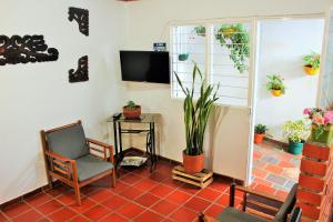Habitación con silla, mesa y TV. en Hospedaje Los Capuchinos, en Socorro