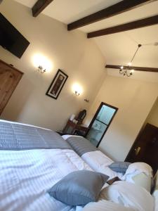 1 dormitorio con 1 cama grande y espejo en Ye Olde Bowling Green Inn en Bradwell