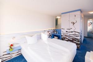 Schlafzimmer mit einem großen weißen Bett und blauem Boden in der Unterkunft Hotel New Orleans in Wismar