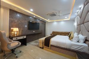 a bedroom with a bed and a desk and a tv at Hotel Y Palace in Ongole