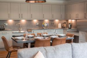 a kitchen with a table and chairs in a kitchen at The Mole Resort - Lodges in Chittlehamholt