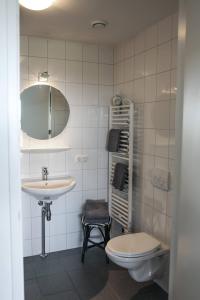 ウェーメルディンゲにあるStrand Appartementen Wemeldinge I Bella Zeelandiaのバスルーム(洗面台、トイレ、鏡付)