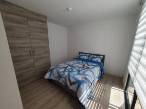 1 dormitorio con 1 cama y armario de madera en Casa El Rincón del Sol, en Quito
