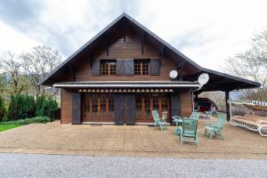 a small house with chairs in front of it at Chalet des Ormes - Maison pour 12 vue montage in Les Combes