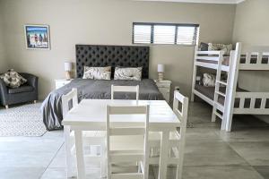 a bedroom with a bed and a table and chairs at Idiaz Beach House in Mossel Bay