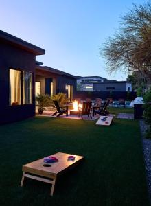 a backyard with a table on the grass at LUXE - Tulum House - New Build - Heated Pool in Scottsdale