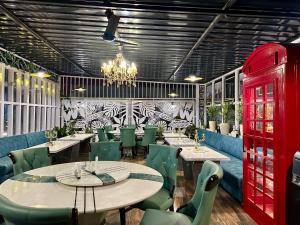 um restaurante com mesas e cadeiras verdes e um lustre em YKC FARMS em Bāghdogra