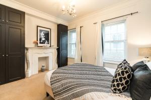 een slaapkamer met een bed en een open haard bij BuckinghamPalace-SuperLuxury-Victoria-Westminster-Belgravia-StJamesPark in Londen
