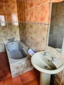 La salle de bains est pourvue d'un lavabo et d'une baignoire. dans l'établissement Deletz Guesthouse, à Witbank