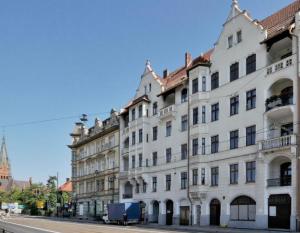 un gran edificio blanco al lado de una calle en Kopernik Premium Rooms Apartment, en Toruń