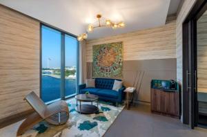 sala de estar con sofá azul y ventana grande en Hyatt Centric Jumeirah Dubai - Executive Room - UAE, en Dubái