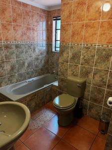 La salle de bains est pourvue de toilettes, d'une baignoire et d'un lavabo. dans l'établissement Deletz Guesthouse, à Witbank