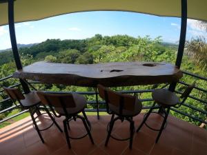 una mesa y sillas en un balcón con vistas en Luxury Villa with Separate Guest house and 360view, en Quepos