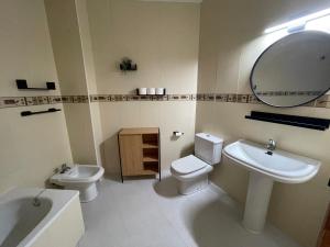 La salle de bains est pourvue d'un lavabo, de toilettes et d'un miroir. dans l'établissement Apartamento Plaza de la Anunciación, à Bélmez