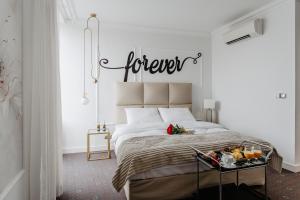 sypialnia z łóżkiem z wiecznym znakiem na ścianie w obiekcie Aroma Stone Hotel Spa w Sycowie