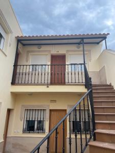 eine Treppe, die zu einem Haus mit Balkon führt in der Unterkunft Apartamento Plaza de la Anunciación in Bélmez