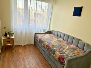 a bed sitting in a room with a window at Kuressaare Pikk Apartment in Kuressaare