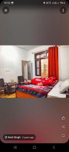 a bedroom with a bed with red sheets and a window at RAHHI HOME STAY in Bīr