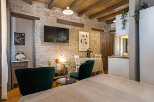 a dining room with a table and green chairs at Casa Kaligari history in Rovinj