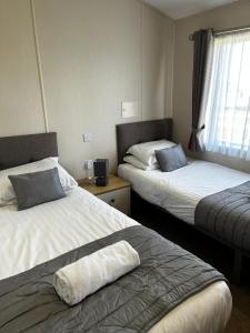 a hotel room with two beds and a window at Burrowhead Holiday Village in Isle of Whithorn +30 photos