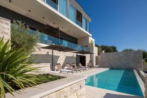 a house with a swimming pool next to a building at Frida's Villa in Dubrovnik