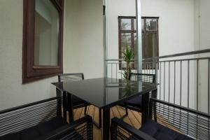 een glazen tafel en stoelen op een balkon bij Bright, modern and central flat with a terrace in Wenen