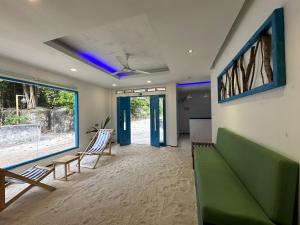 a living room with a green couch and chairs at Atholhu Beach club in Fehendhoo