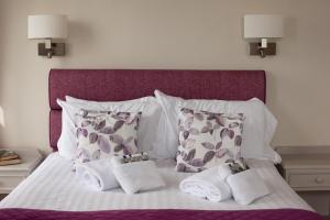 Una cama blanca con toallas y almohadas. en Redcliffe Hotel, en Paignton