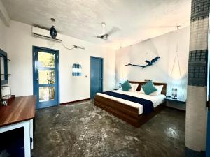 una grande camera da letto con letto e camino di Atholhu Beach club a Fehendhoo